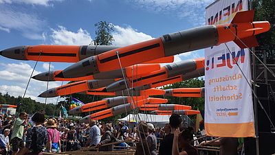 Das Bild zeigt Raketenförmige Luftballons auf einer Protestkundgebung am Fliegerhorst in Büchel.