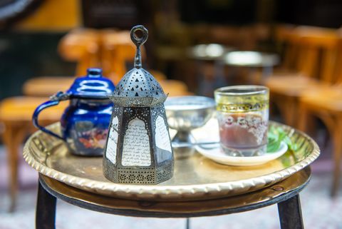Auf dem Bild ist ein Tisch mit Ramadan-Laterne, einer Tasse Tee und Datteln für das abendliche Fastenbrechen zu sehen.